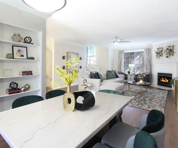 a living room with a table with a vase with yellow flowers