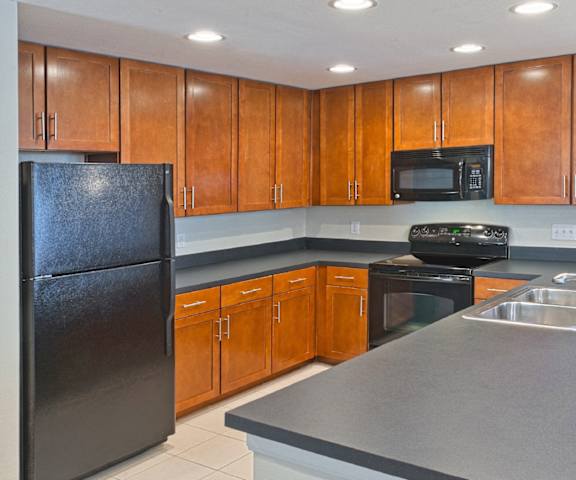 a kitchen with black appliances and wooden cabinets
