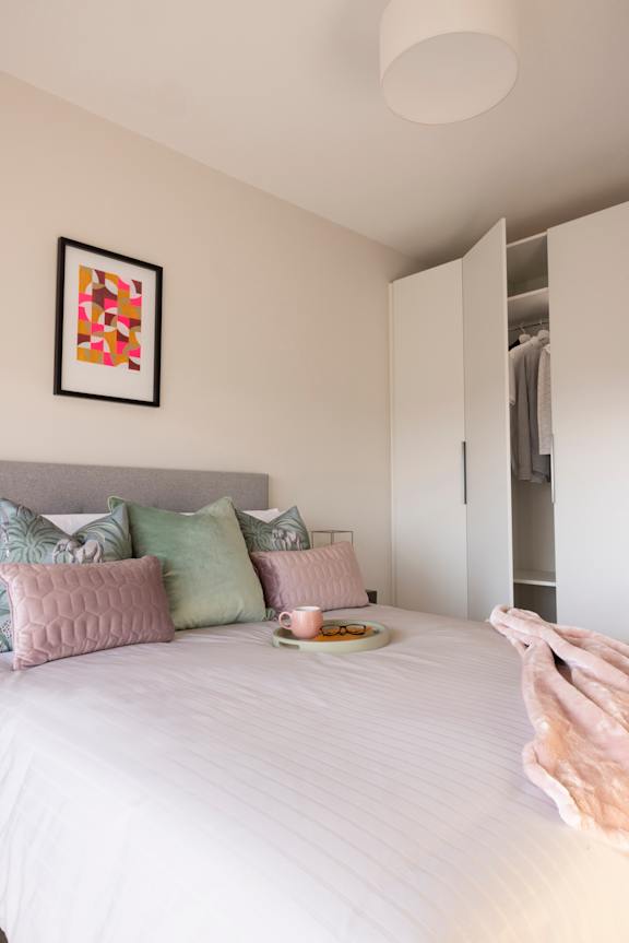 a bedroom with a bed with pillows and a closet