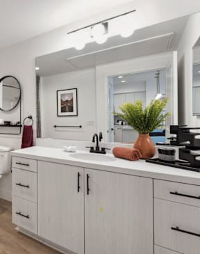 A bathroom with a white toilet, a white bathtub, a white sink, and a white vanity.
