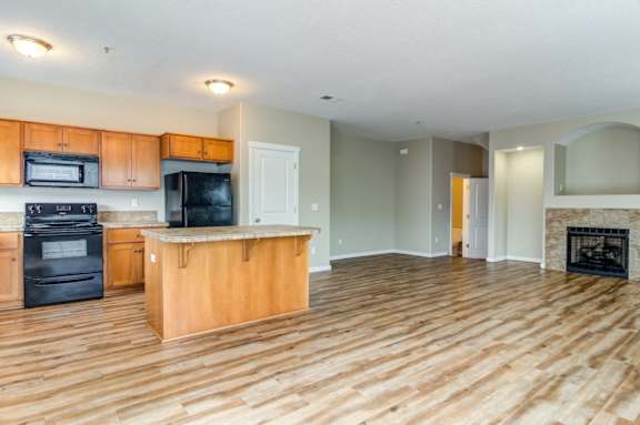 Latitude Apartments and Townhomes in Happy Valley, Oregon Kitchen with Island and Living Room with Fireplace
