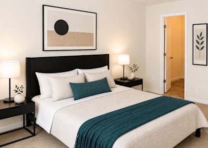 A bedroom with a large bed and a painting above it.