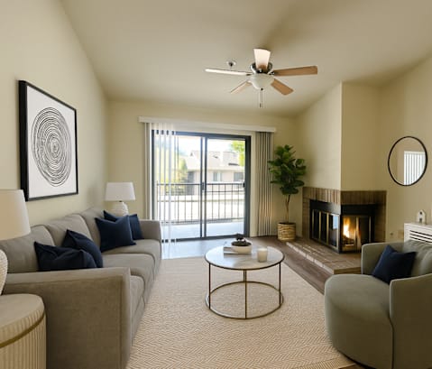 A living room with a grey couch, a coffee table, a fireplace, and a television.