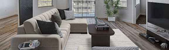 A living room with a grey sofa, a coffee table, a ceiling fan, and a sliding glass door.