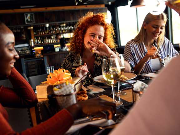 A group of people are enjoying a meal together at a restaurant.