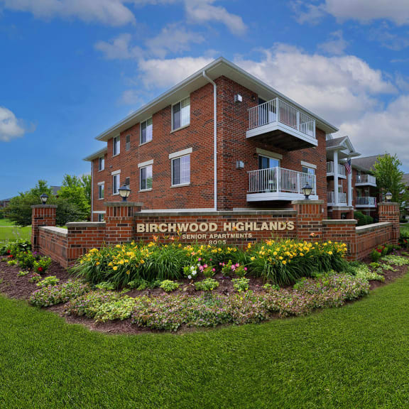 the front of the brickwood highlands building with a garden in front of it