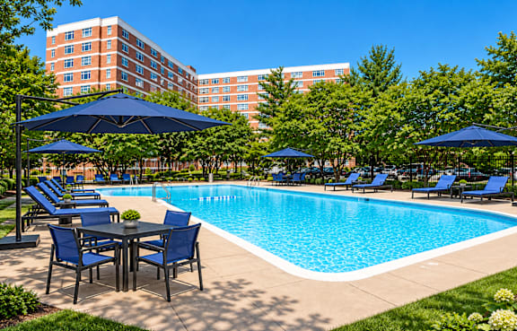 A large room with a pillar, chairs, and a table at Dominion Towers Apartments, Virginia