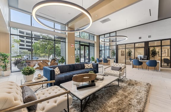 A modern living room with a large circular light fixture and a variety of seating options.