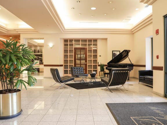 a large lobby with a piano and chairs at Symphony Center Apartments, Baltimore, MD, 21201