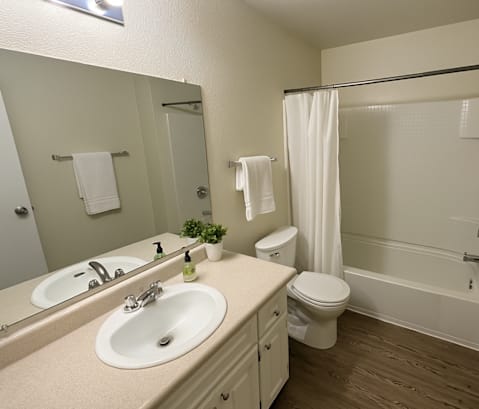 A bathroom with a toilet, sink, and shower.