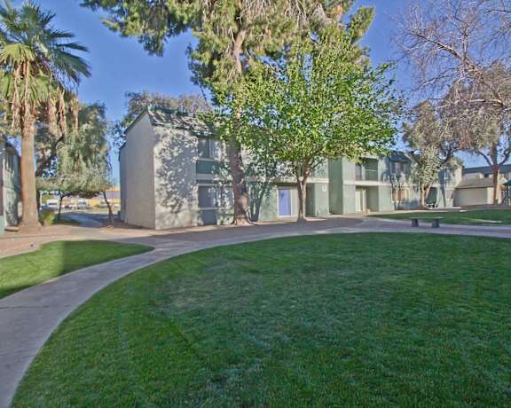 A grassy area with a pathway and trees in front of a building. at Missouri Crossing, Phoenix, Arizona