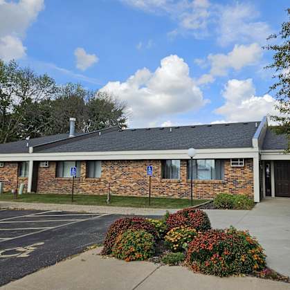 A building with a brick facade and a parking lot in front.