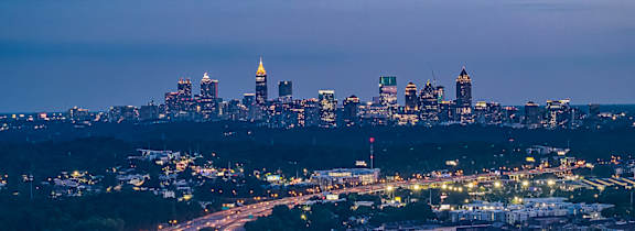 A cityscape at dusk with a highway running through it.