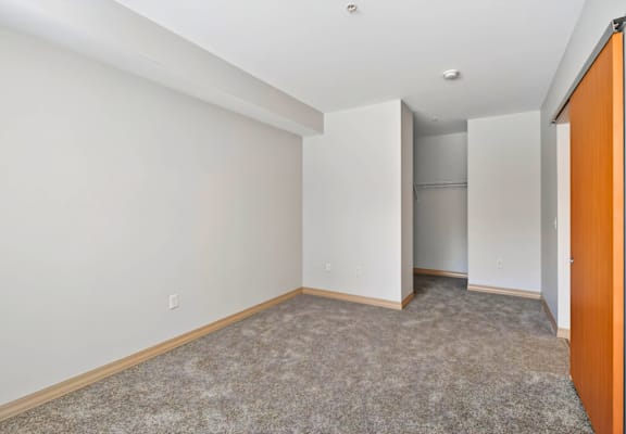 A room with a carpeted floor and a wooden door.