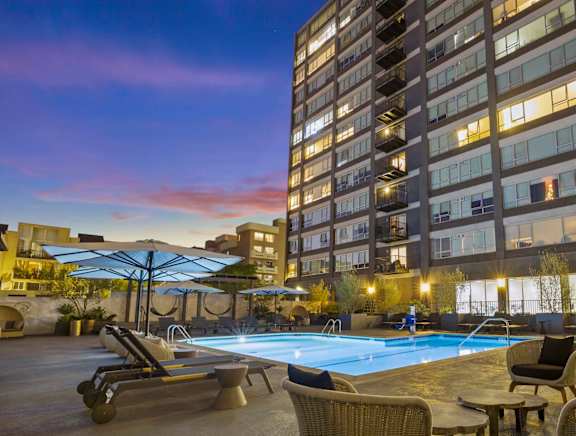 A large building with a pool and lounge chairs. at The View, Los Angeles, California