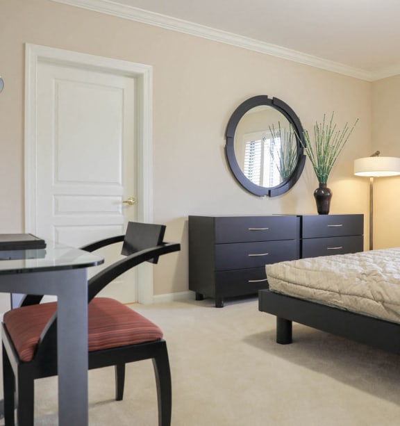 a bedroom with a bed and a desk with a chair at Symphony Center Apartments, Baltimore, MD, 21201