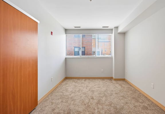 A room with a brown door and carpeted floor.