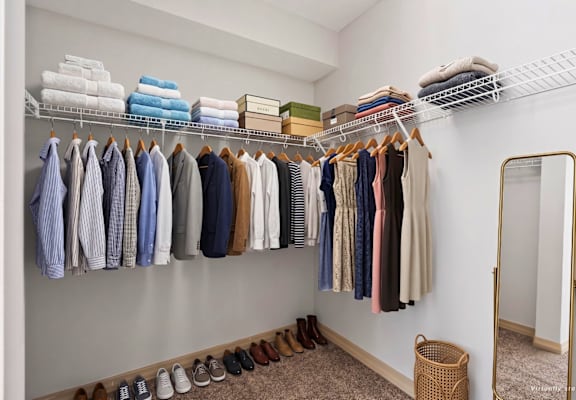 A well organized closet with clothes and shoes.