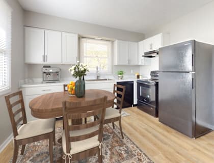 a kitchen with a table and a refrigerator at Stonebrook of Franklin, Franklin, IN, 46131