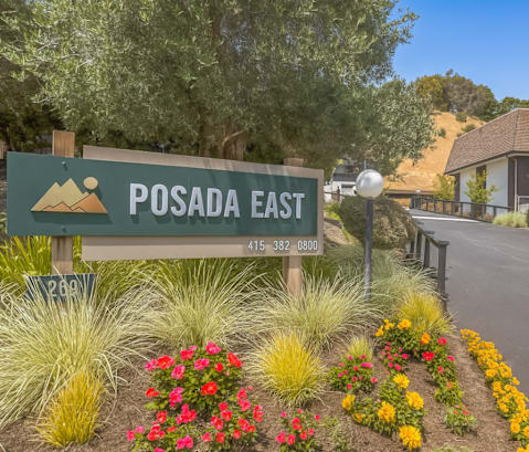A sign for Posada East with a mountain graphic on it.