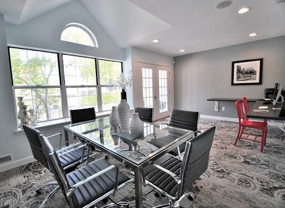 a dining room with a glass table and chairs at Village Club on Franklin, Southfield Michigan