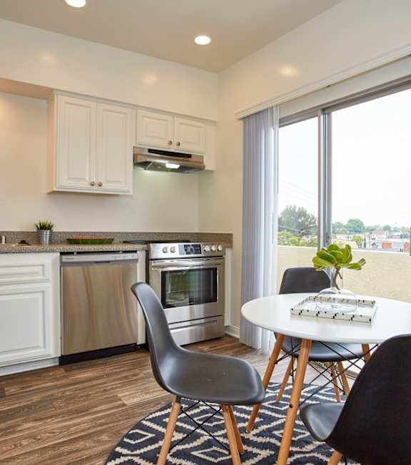 A well-lit, modern kitchen and living room with a dining area.