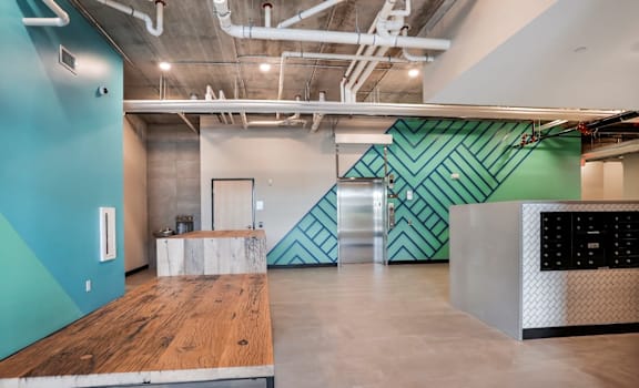 A room with a wooden floor and a green wall with a black and white pattern.