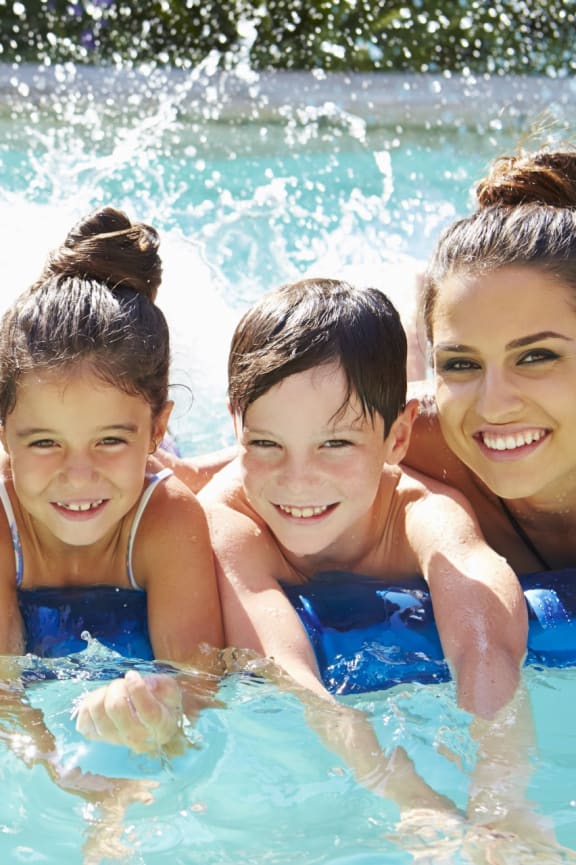 Family Smiling while Having Fun in Pool Together