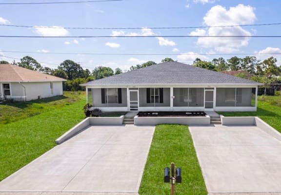 A house with a grey roof and a white fence.
