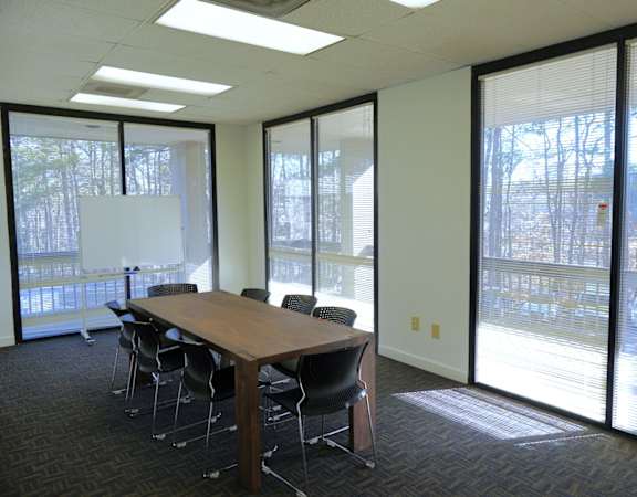 A conference room with a long table and chairs.