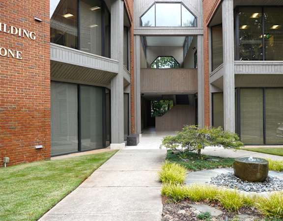 A courtyard with a fountain and a building in the background.