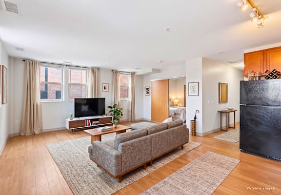 A living room with a couch, a coffee table, and a television.