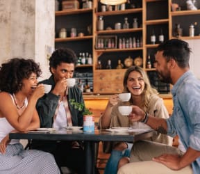 a group of people sitting at a table drinking coffee