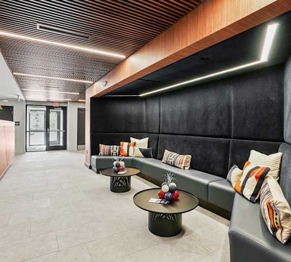 A long hallway with a black couch and a coffee table.