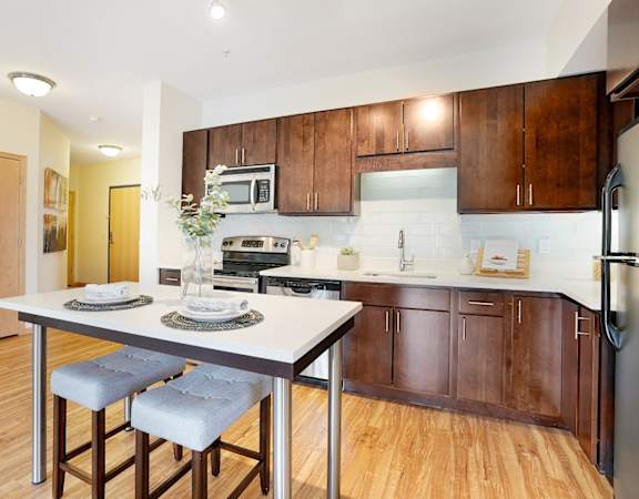 A kitchen with a table and chairs in the middle of it.