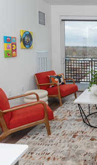 a living room with a large window and a couch and chairs