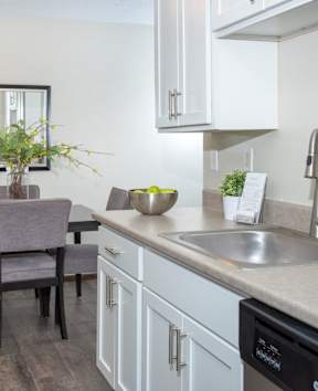 A kitchen with a black refrigerator and stainless steel appliances.