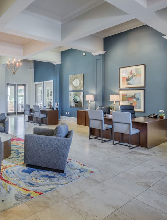 a lobby with couches chairs and tables and a reception area