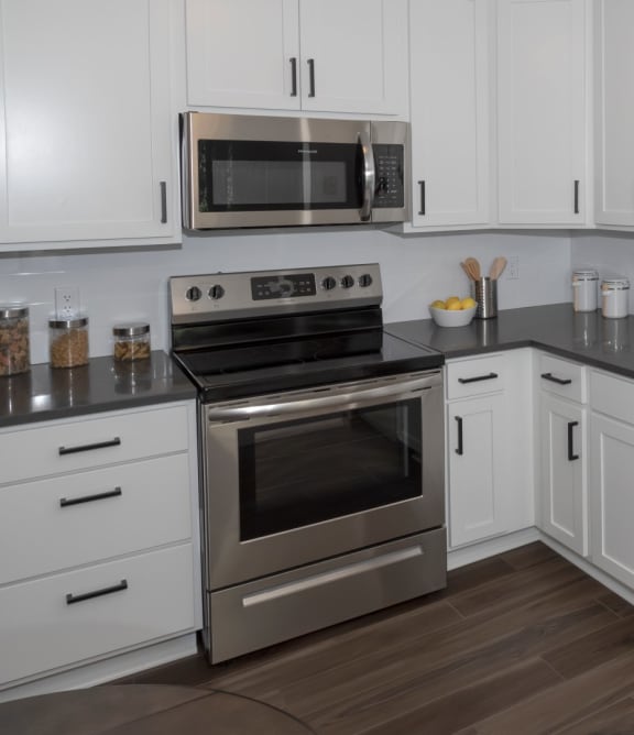 a kitchen with white cabinets and stainless steel appliances