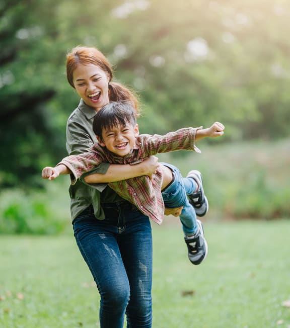 Mom and kid playing in playground at Archer Village Apartments, TX, 75092