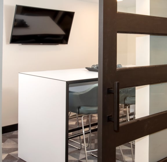 an open door leading into a conference room with a tv on the wall