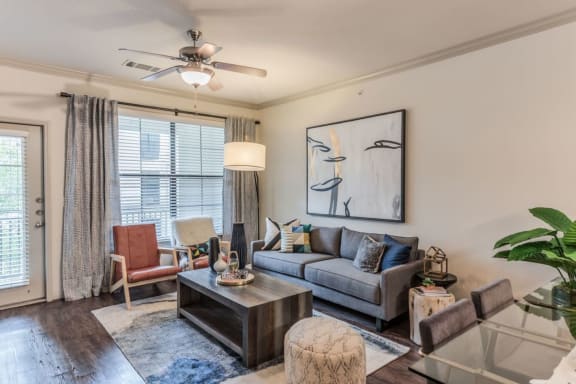 a living room with a couch coffee table and a ceiling fan