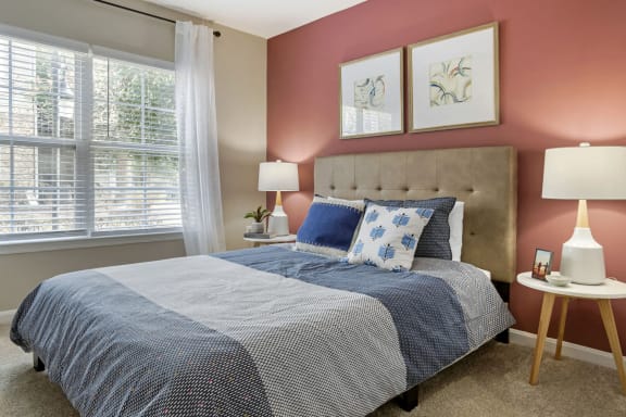 a bedroom with a bed and two windows