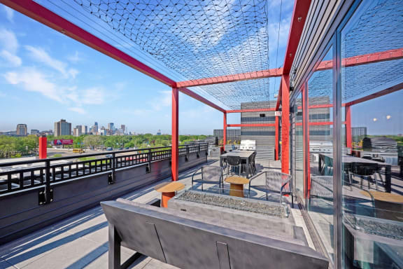 a rooftop terrace with tables and chairs and a view of the city