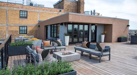 A patio with a table and chairs is surrounded by a brick wall.