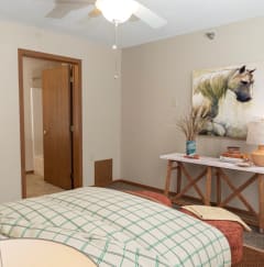 a bedroom with a bed and a desk with a lamp