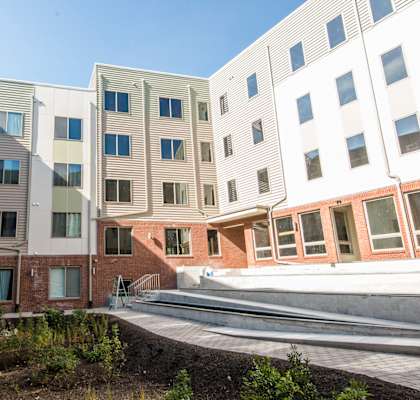A modern building with a landscaped courtyard in front.