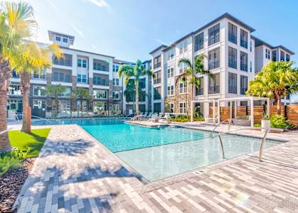 Resort-style pool with expansive sundeck and pergolas at at Tapestry Nona Apartments in Orlando, FL