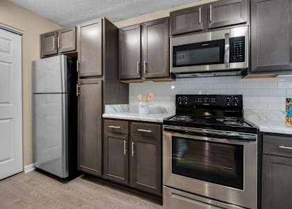 A kitchen with a black stove top oven and stainless-steel appliances at Crystal Lake in Pensacola, Florida.