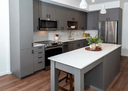 a kitchen with gray cabinets and a white counter top